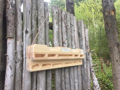 freesolo Hangboard Holz-Hangboard hängt auf einem Holzzaun
